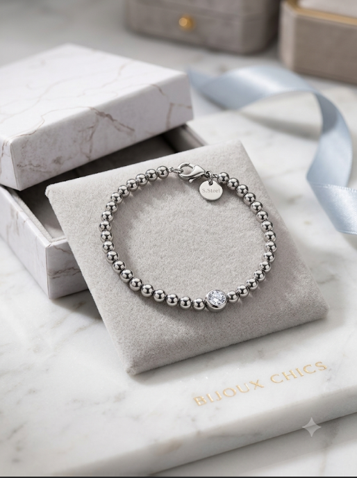 Bracelet perles argentées avec solitaire cristal sur présentoir marbre
